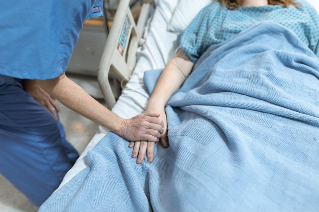 Enfermera cuidando a persona en cama con incapacitación judicial