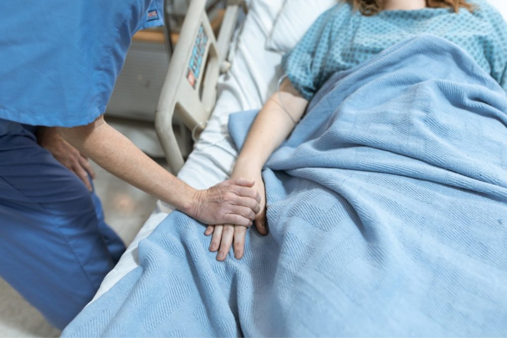 Enfermera cuidando a persona en cama con incapacitación judicial