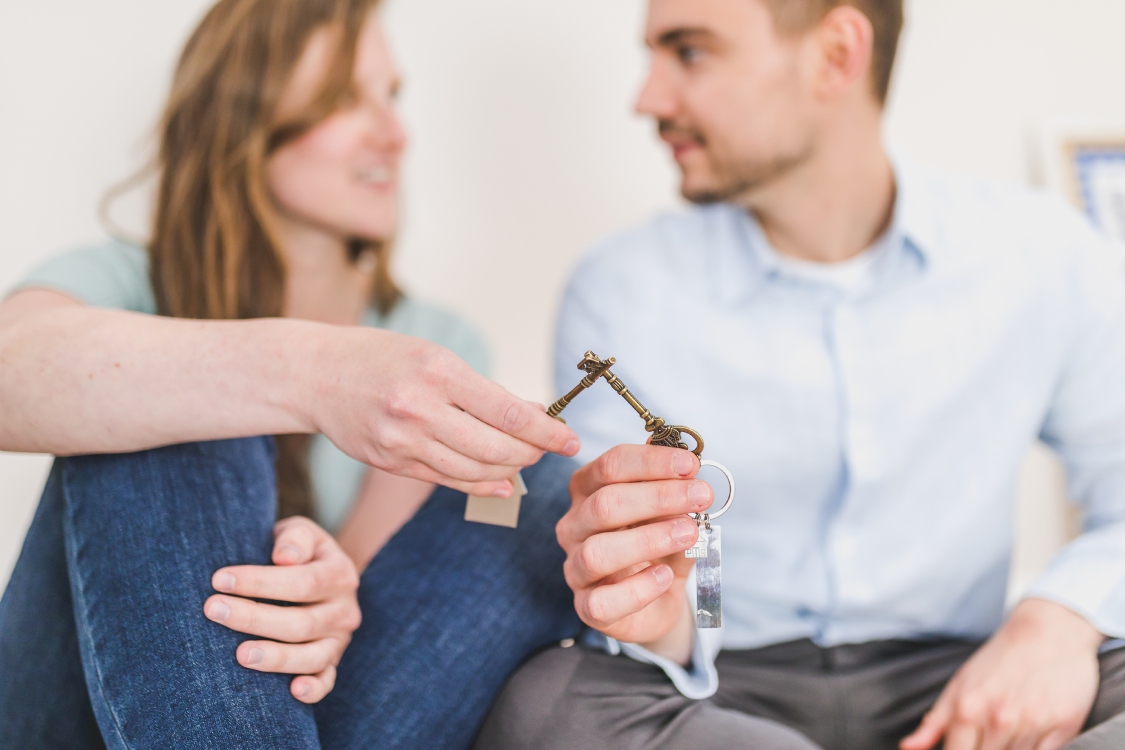 Hombre y mujer sosteniendo llaves de vivienda